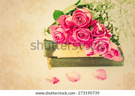 blur style bouquet of pink roses on old books floral background is love tenderness vintage retro selective soft focus