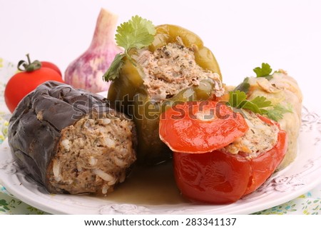 Stuffed eggplant pepper tomato cabbage leaves ground meat with rice and green on a white background