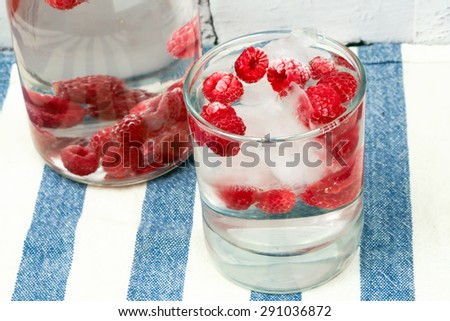 cold water with frozen raspberries and ice summer hot