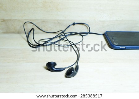 headphones with mobile phone on wood