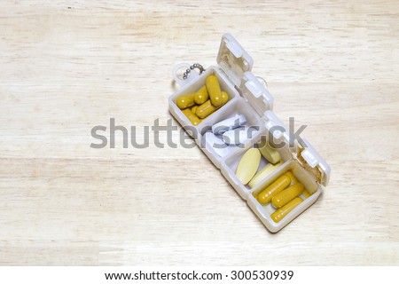 pill box and pills on wood