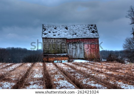 Old barn with flower bed in winter
