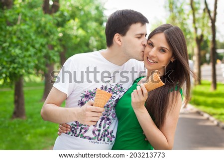 love couple out in the park with ice cream kissing in the open air