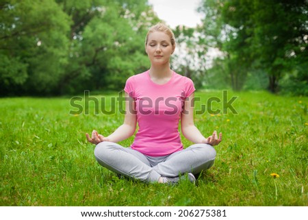 blonde girl outdoor in the park wearing grey shoes and pink t-shirt. yoga