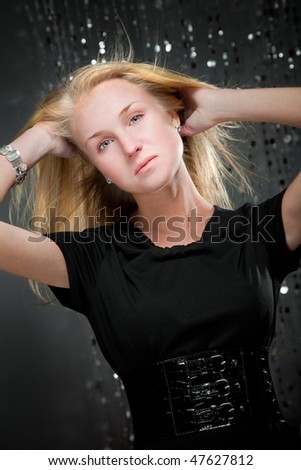 Blonde girl in black dress and wide belt. shot in studio