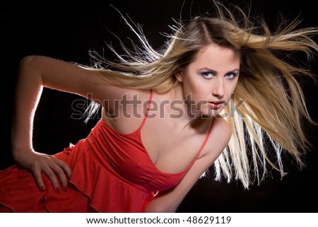 portrait of blonde girl in red dress with flying hair