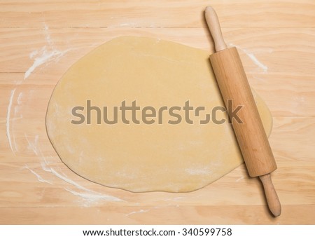 rolling pin and dough on wooden background