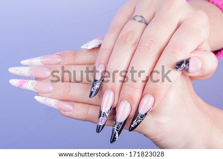 Woman hand with dark and pink nails, isolated on blue background