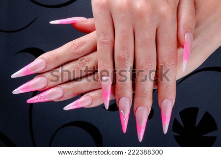 Pretty woman hand with perfect extreme long painted pink nails