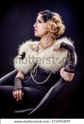 Retro portrait of beautiful blonde woman with gold and pearl jewels and extreme long nails. Gatsby, Vintage style. Isolated on black background