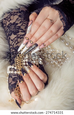 Retro jewels and extreme long nails on white fur. Gatsby, Vintage style