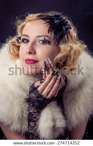 Retro portrait of beautiful happy smiling blonde woman with jewels and extreme long nails. Gatsby, Vintage style. Isolated on black background