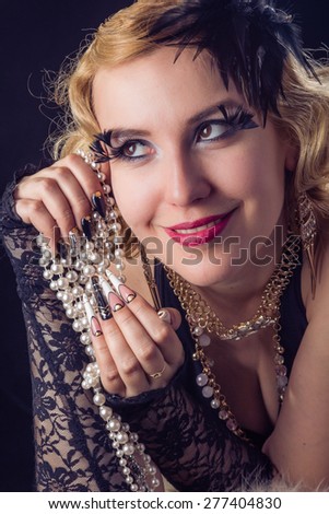 Retro portrait of beautiful happy blonde woman with jewels and extreme long nails. Gatsby, Vintage style. Isolated on black background