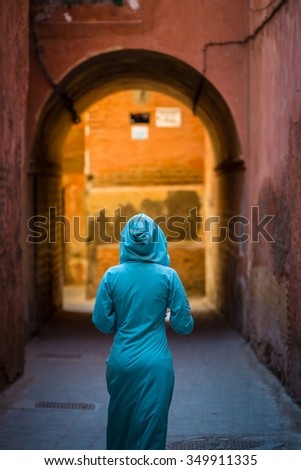 traditionally clothed arabic woman walking in the medina of marrakech