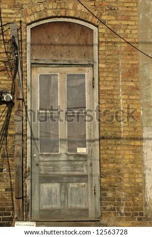 old back-door with no steps in brick-wall