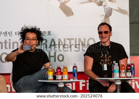 Busan, South Korea, October 11: Quentin Tarantino sits with Korean director Bong Joon Ho takes a picture of the crowd at the Busan International Film Festival October 11, 2013 in Busan, South Korea