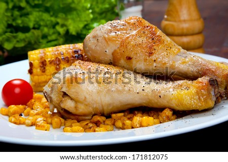 chicken thigh with a boundary of corn cob and salad