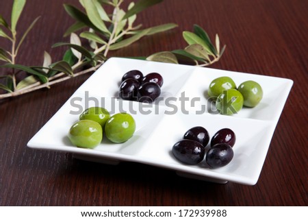 Green and black olives in a dish