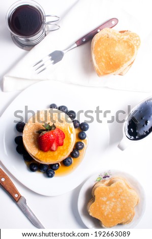 Pancakes with honey, berries, coffee and jam