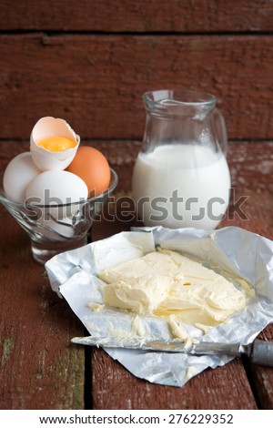 butter, milk and eggs on wooden boards