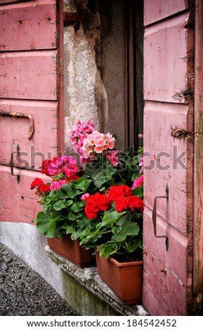 Vases of flowers on the marble top of an old pink wooden window