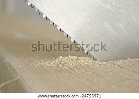 A picture showing the toothed edge of a saw cutting into timber