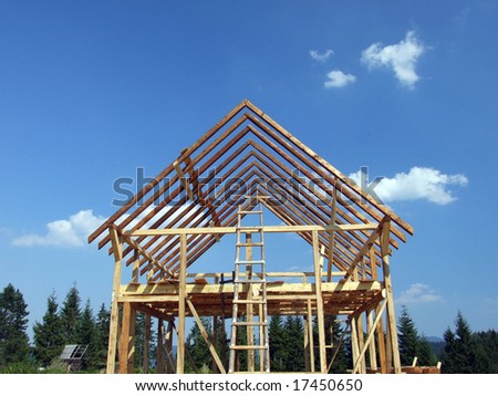 Wooden house under construction on a sky background