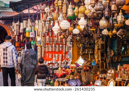 MOROCCO, MARRAKESH - DECEMBER 28: a local family walk in the souq in front of a lamps shop on December 28, 2014 in Marrakesh, Morocco