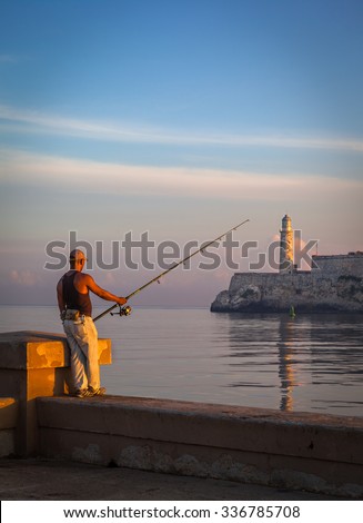 HAVANA, CUBA - CIRCA AUGUST, 2015: Cuban man fishing in front of the famous fortress of El Morro, Havana, Cuba