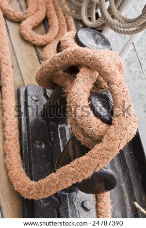 large rope tied down to deck of tall ship