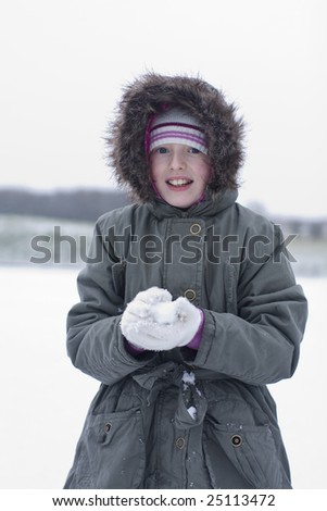 girl playing in the snow making snow balls