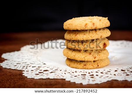 Close up of stacked apple chip cookies on white rustic napkin with wooden background
