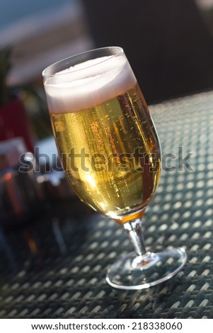 A glass of beer in a sunset on a terrace table