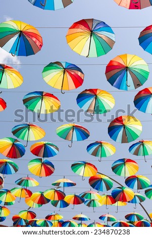 Many rainbow umbrellas strung across the street