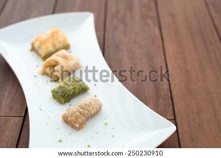 Variety of turkish baklava on a white porcelain plate. Shallow DOF