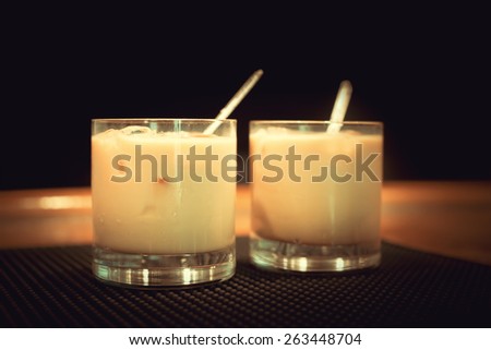 Preparation of white russian cocktails on the bar counter on rubber mat. Shallow DOF and marsala tonned