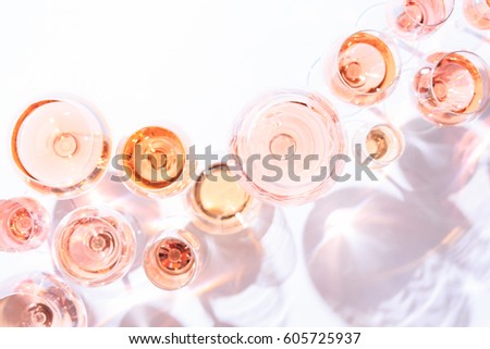 Many glasses of rose wine at wine tasting. Concept of rose wine and variety. White background. Top view, flat lay design. Direct sunlight. Toned image.
