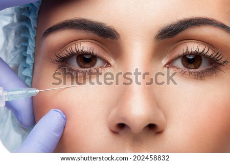 Cosmetic injection to the pretty woman face on white background