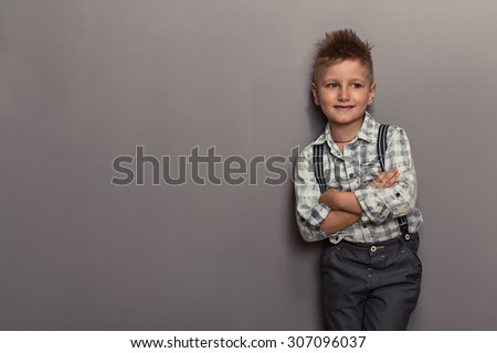 Fashion boy pointing down on grey background
