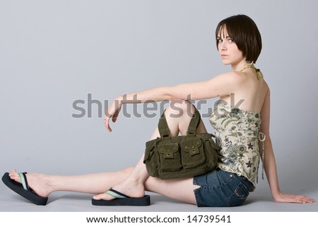 Cute girl sitting and posing with her purse