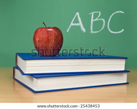 ABC written on a chalkboard with an apple over books.
