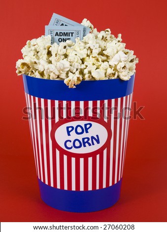 A popcorn bucket over a red background. Movie stubs sitting over the popcorn.