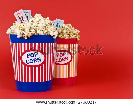 Two popcorn buckets over a red background. Movie stubs sitting over the popcorn.