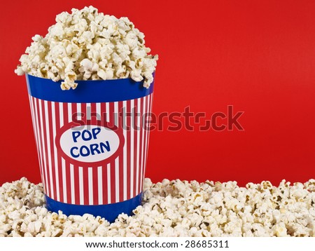 A popcorn bucket over a red background.