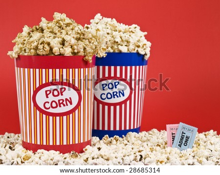 Two popcorn buckets over a red background.