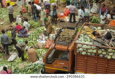 BANGALORE, INDIA - May 27, 2014: Aerial view of the busy city market, vendors sell produce, a man asleep on top of a truck.