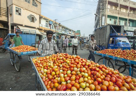 BANGALORE, INDIA - May 13, 2014: An unidentified vegetable seller pushes a cart full of tomatoes to be sold in the city vegetable market