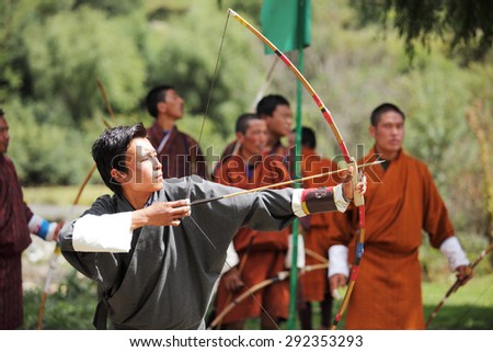 BUMTHANG, BHUTAN - OCTOBER 5, 2010:  A group of Bhutanese men compete in the national sport of archery a festival