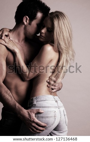 A sexy young topless couple embracing in jeans