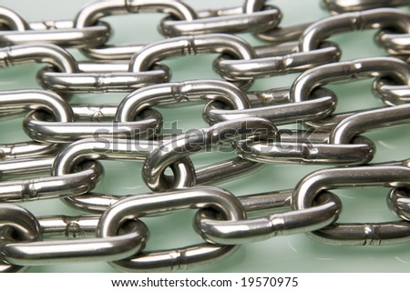 Multiple strands of chrome chain on a glass surface